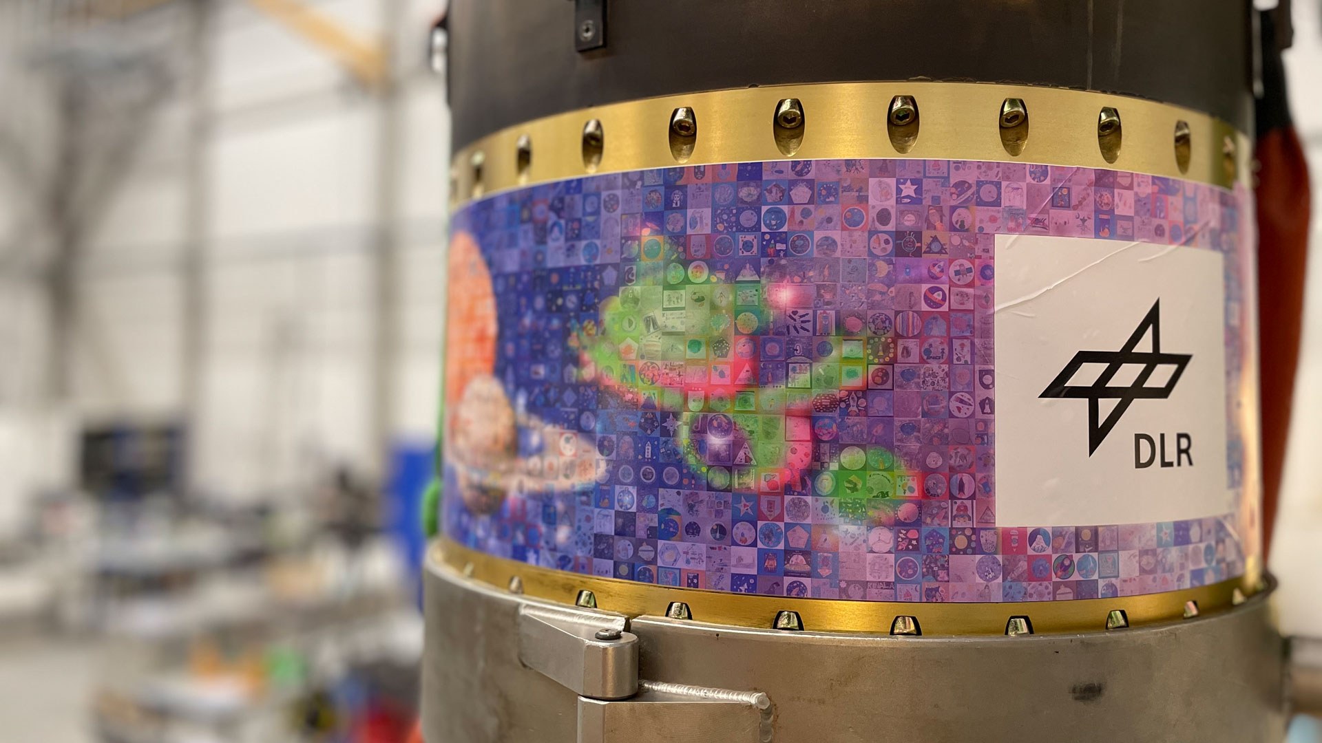 Die von den Kindern gestalteten Missionslogos wurden als Mosaikbild auf die Außenhülle der Rakete geklebt. Alle eingesendeten Bilder befanden sich auf einem USB-Stick im Innern der Höhenforschungsrakete MAPHEUS-13 – und haben so den Weltraum erreicht.