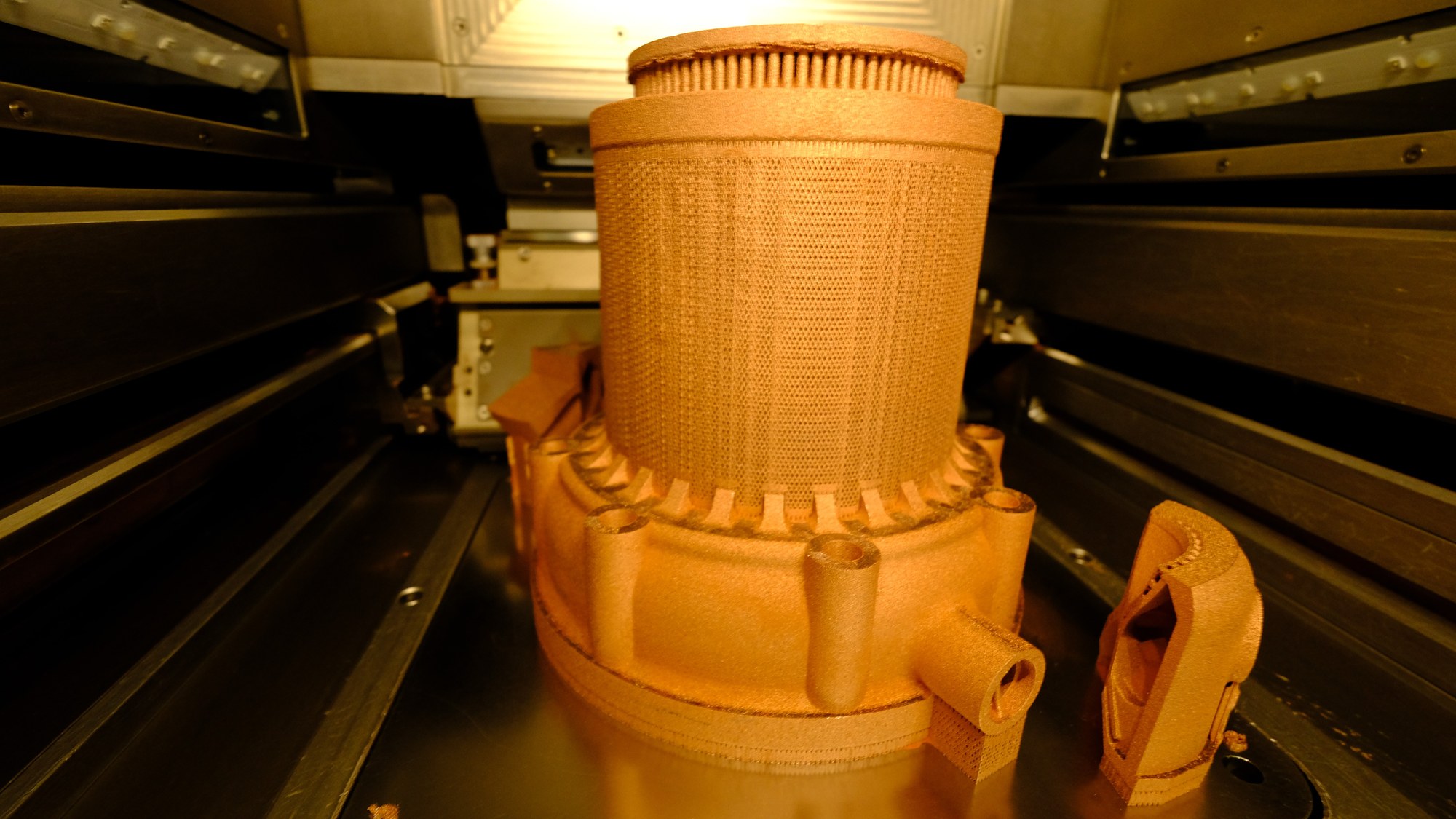 Das Bild zeigt die 3D-gedruckte Brennkammer in einem DLR-Labordrucker.
