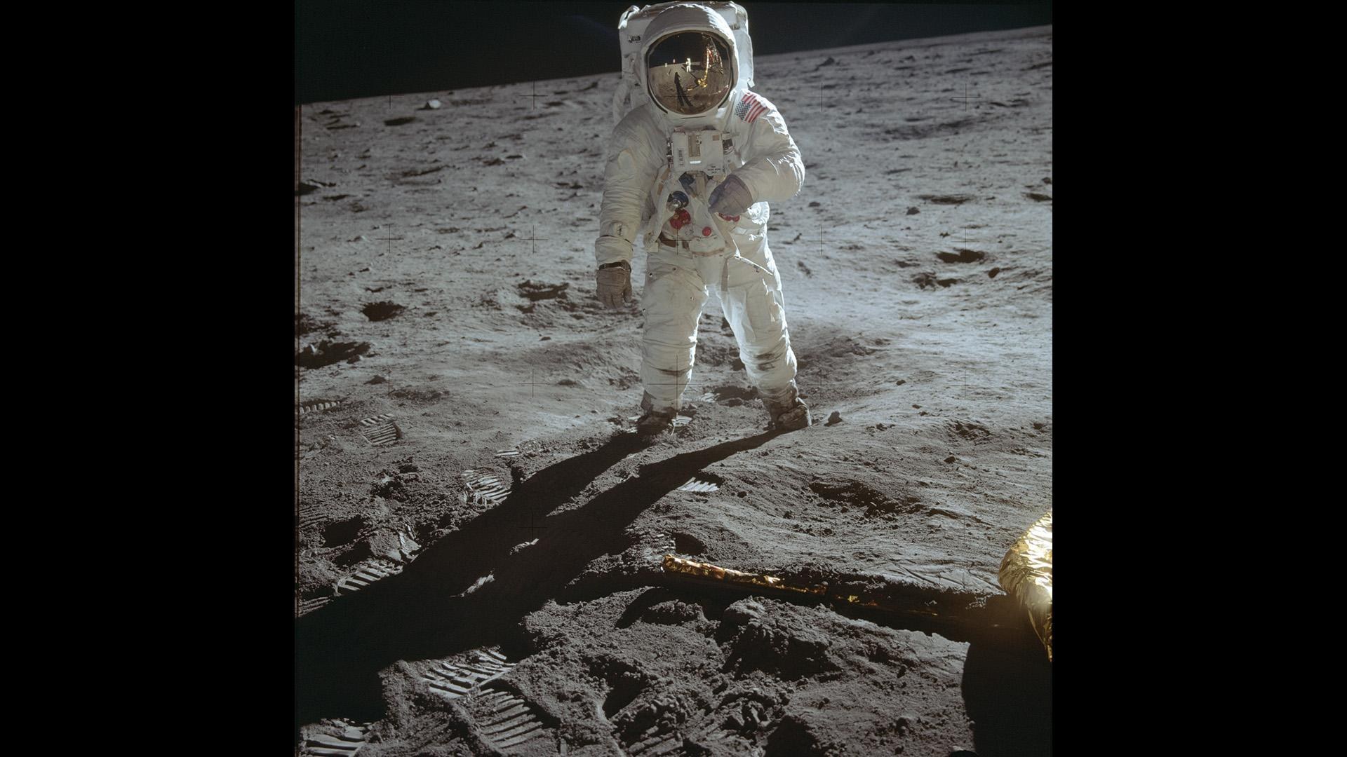 Das Bild zeigt die beiden ersten Menschen auf dem Mond: Aldrin, wie er vor Armstrong steht, und Armstrong, wie er sich im Moment der Aufnahme im Visier von Aldrin spiegelt.