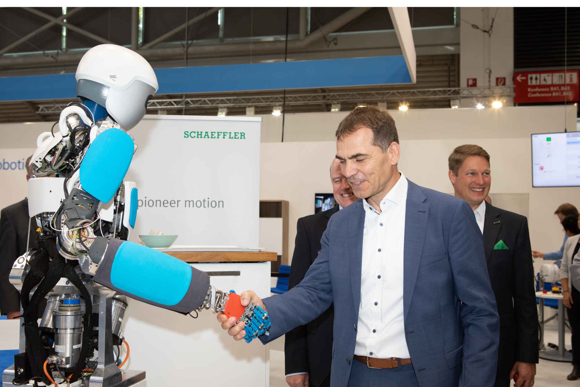 Uwe Wagner, Vorstand Forschung und Entwicklung der Schaeffler AG, schüttelt Hände mit DLR-Roboter David auf dem DLR-Messestand der automatica 2022.