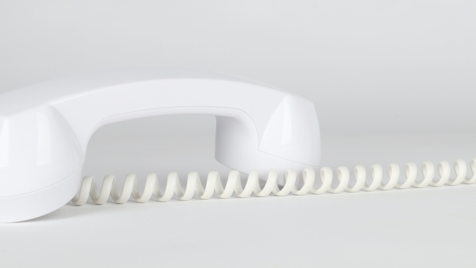 A white telephone with cord