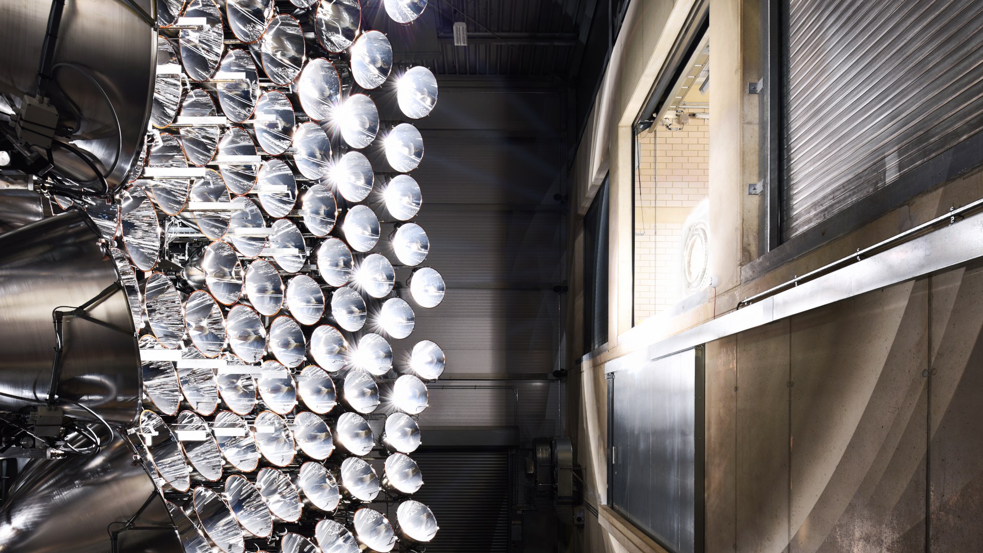 The High-flux solar simulator Synlight at DLR's Jülich site irradiates one of the three experimental chambers.