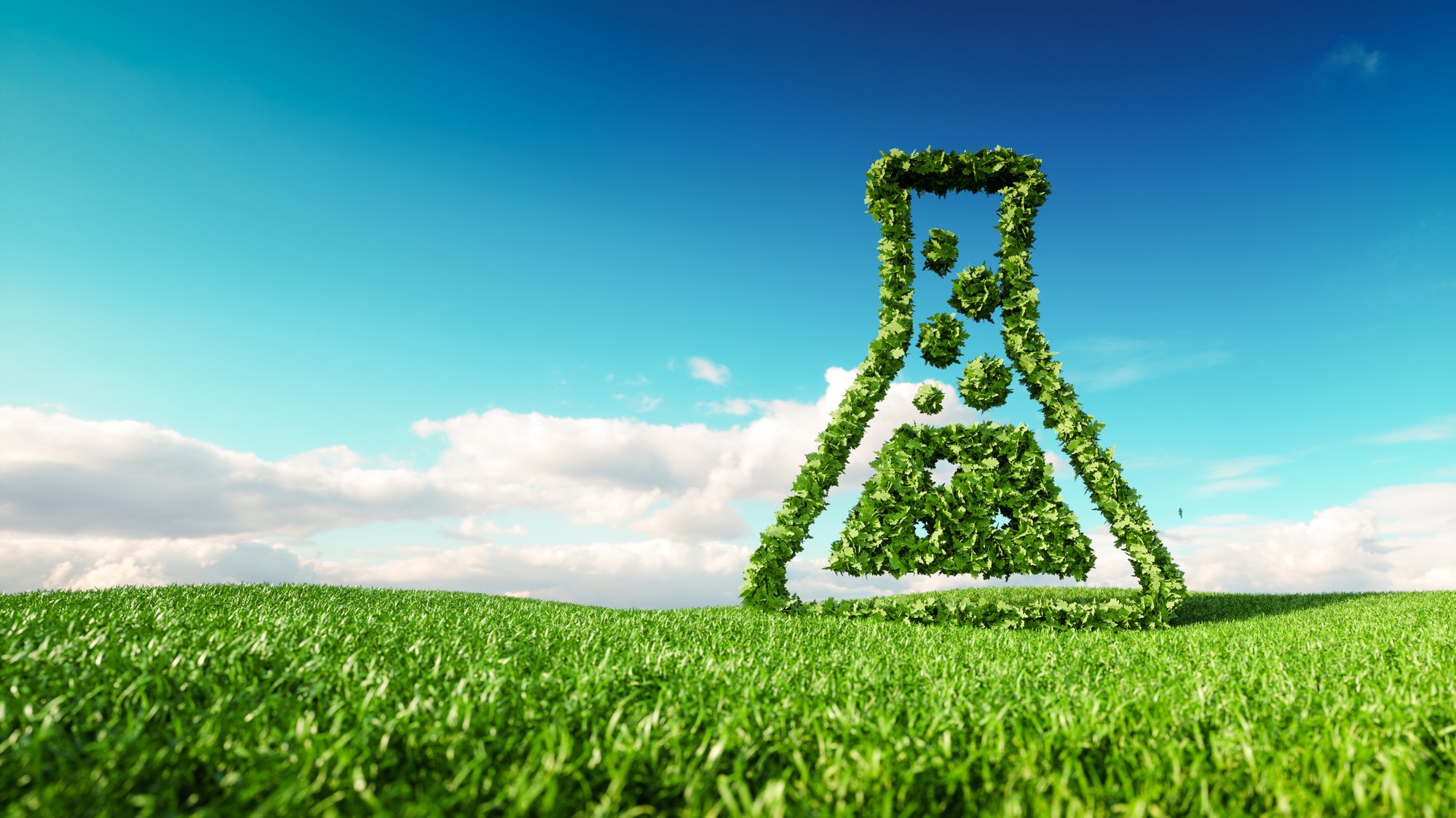 A green animated Erlenmeyer flask standing on a green meadow