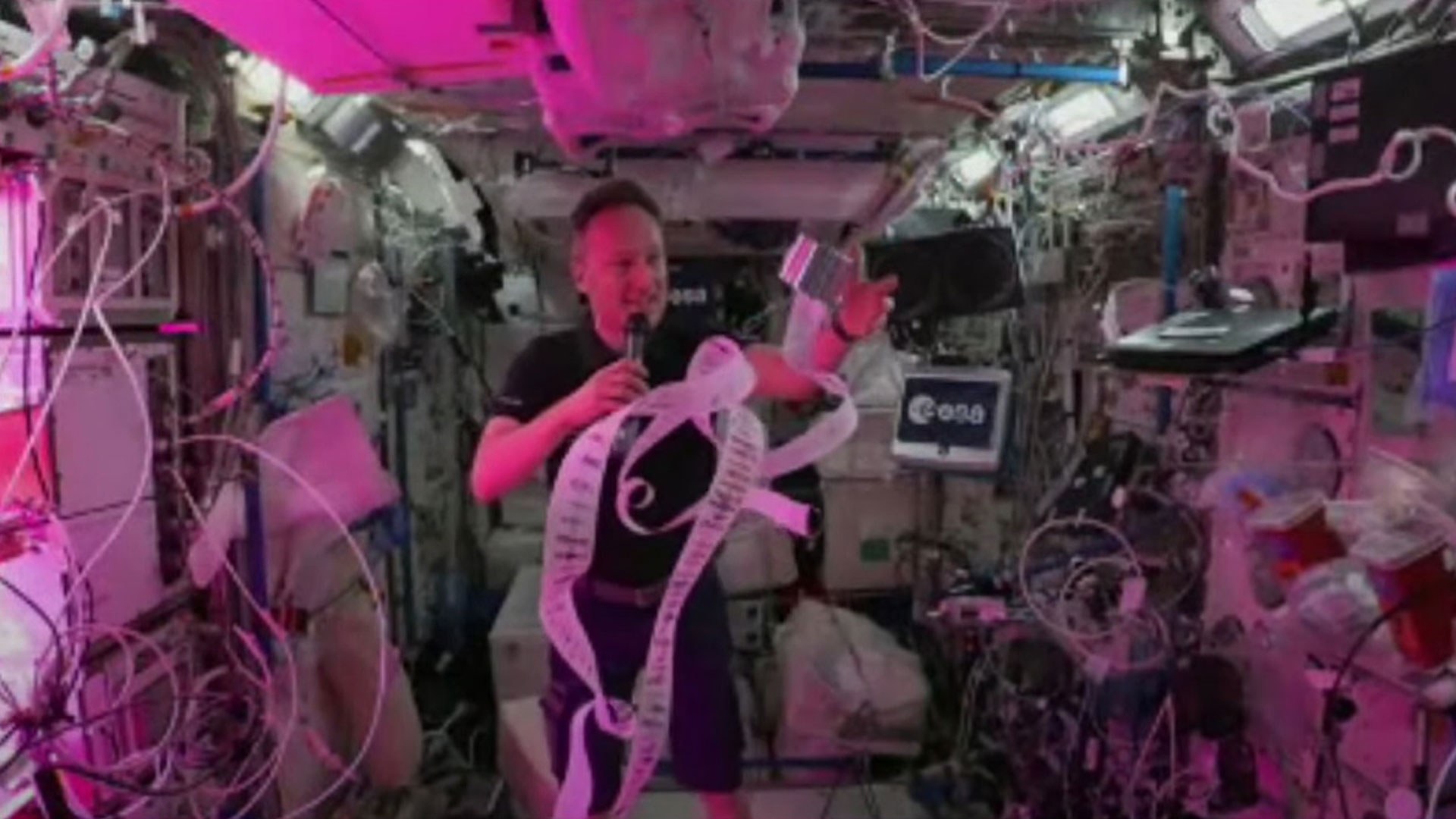 ESA astronaut Matthias Maurer unrolls the image strip