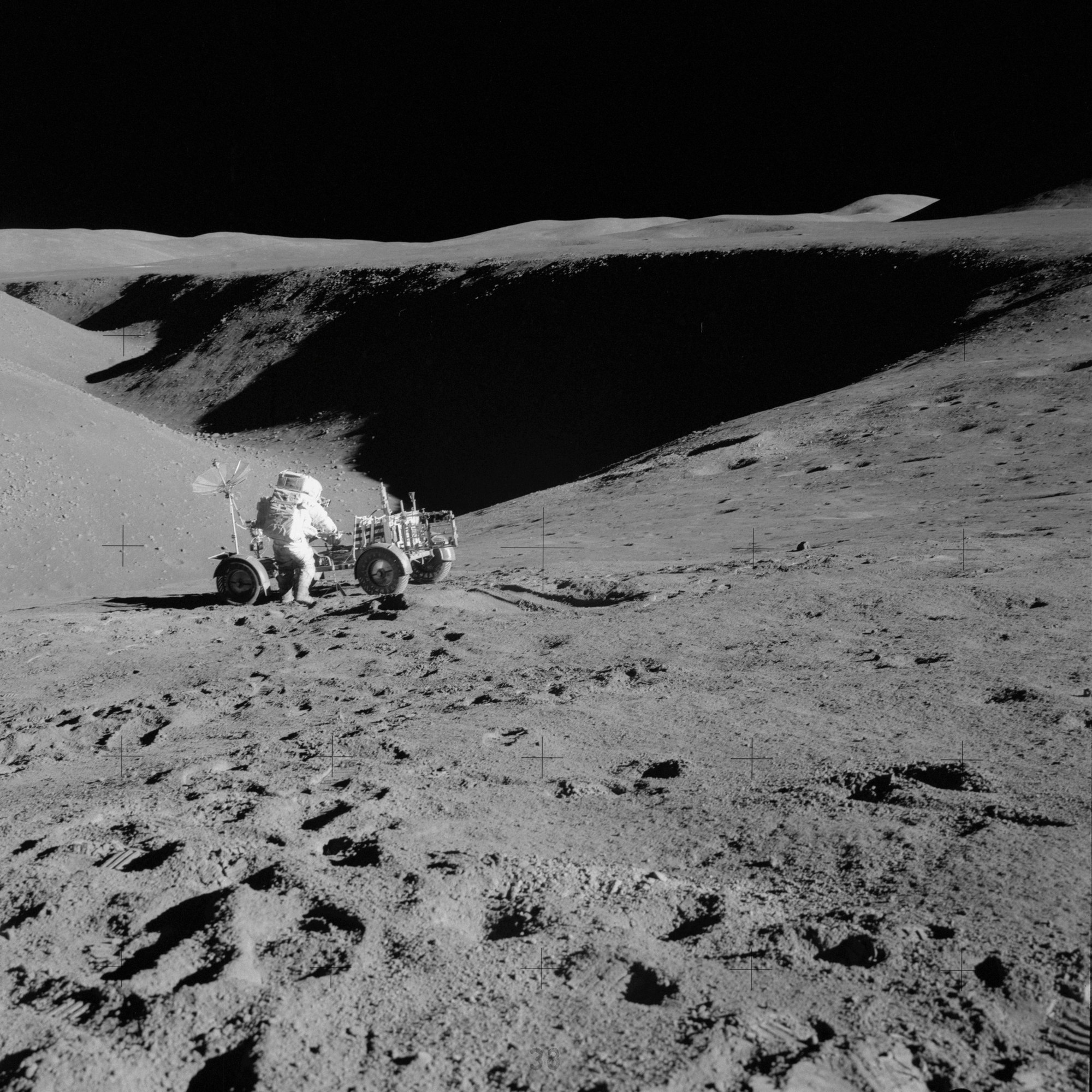 David Scott performs tasks at the lunar rover parked on the edge of Hadley Rille