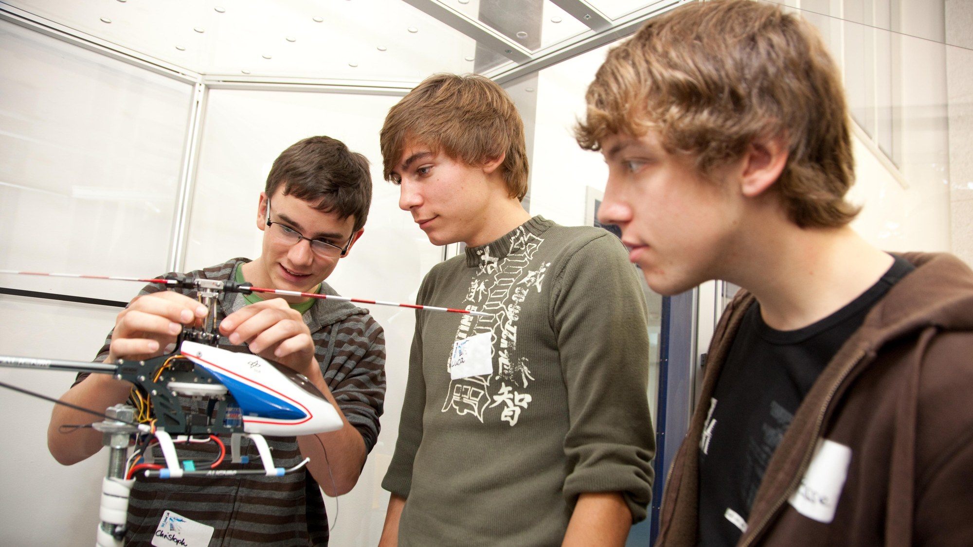 Three students and a model helicopter