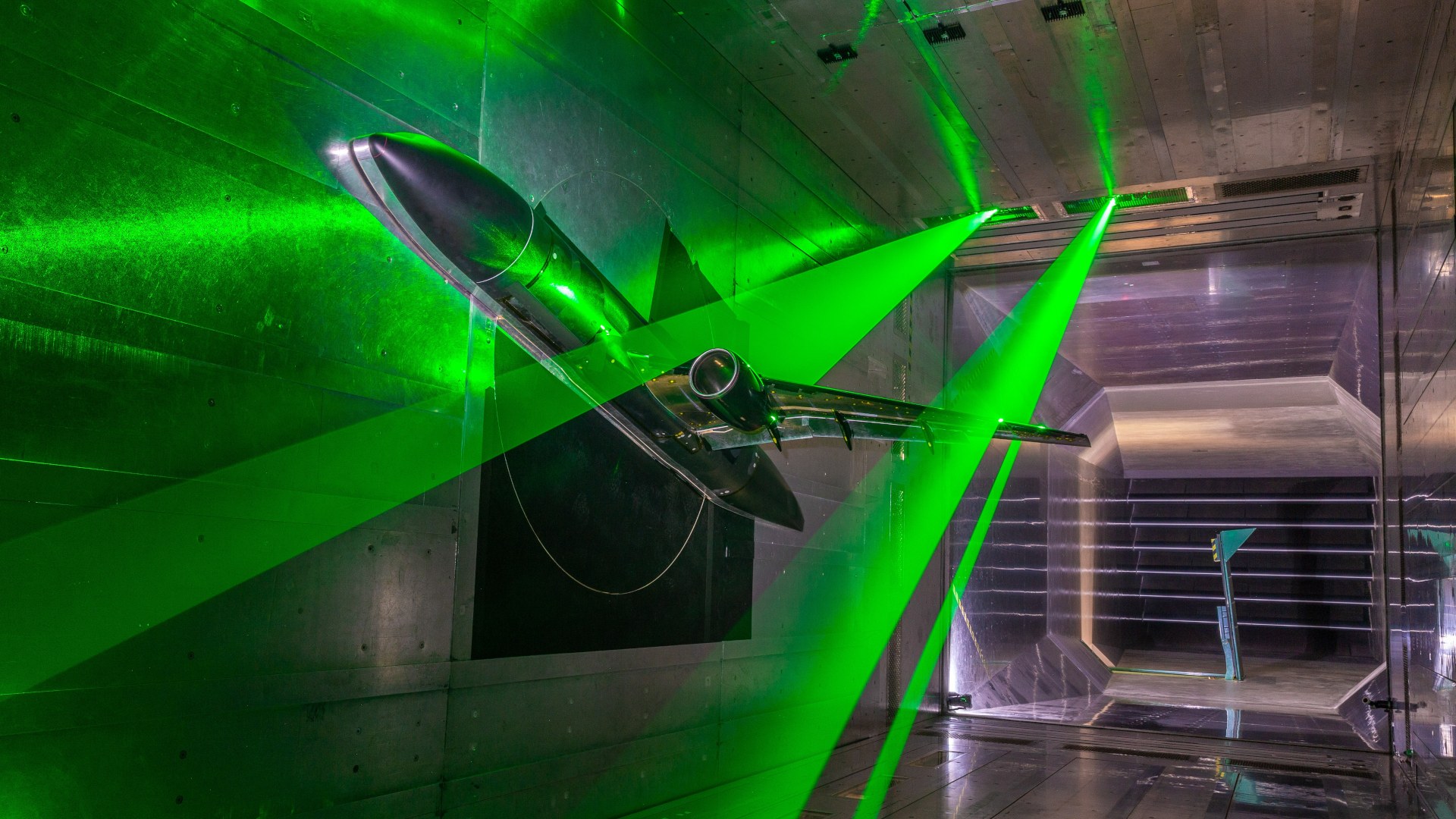 The NASA aircraft model inside the DNW Braunschweig Low-Speed Wind Tunnel (DNW-NWB). 'Sheets' of laser light illuminating the inner and outer wings are used to measure flow velocities.