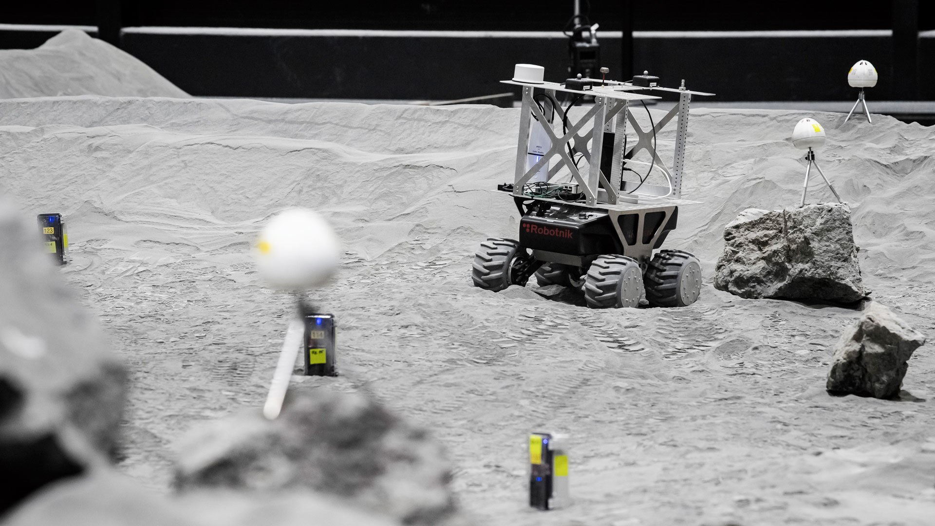 A rover moves between sensors and stones in the LUNA hall