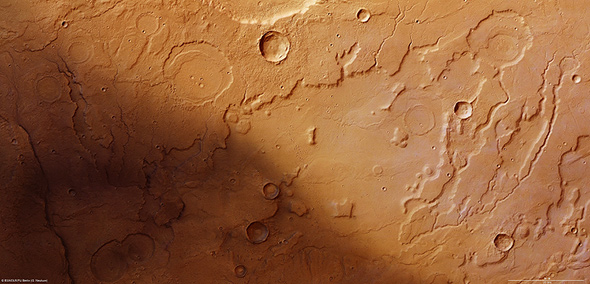 Dieses Bild der vom DLR entwickelten Kamera HRSC zeigt das Tiefland Acidalia Planitia auf der Nordhalbkugel des Mars. Man erkennt auch ausgetrocknete Flusstäler, die belegen: Hier muss früher einmal Wasser geflossen sein. In dieser Gegend beginnt die Geschichte von Mark Watney, der im Film von Matt Damon gespielt wird – mehr wird nicht verraten! Bild: ESA, DLR, FU Berlin