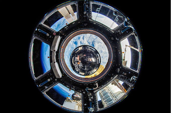 Am 5. Juli 2018 hat uns dieses Foto erreicht: die Zeitkapsel an Bord der ISS! Alex  hat es im Cupola-Modul aufgenommen, das viele Fenster hat – mit der Erde im Hintergrund. Und er selbst spiegelt sich bei genauem Hinsehen auch in der Metallkugel. Bild: ESA/DLR CC-BY 3.0