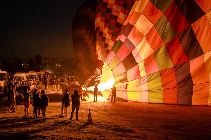Heiße Luft dehnt sich aus und füllt den Ballon, bis er auch mit Korb und allen Passagieren leichter ist als die umgebende Luft und abhebt. Bild: Sami Aksu / Pexels 