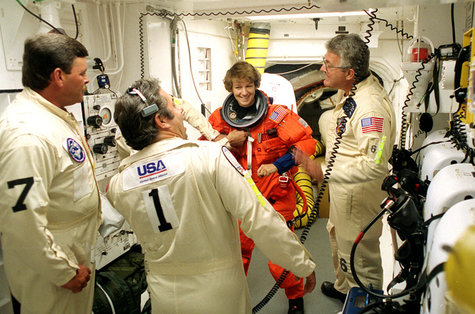 Der „White Room“ befindet sich ganz oben an der Startrampe. Hier steigen die Astronauten in die Raumfähre ein, bevor der Turm zur Seite fährt und der Shuttle dann startet. Eileen Collins ist offenbar gut gelaunt und scherzt mit den Technikern. Sie war die erste Frau, die als Kommandantin eine Shuttle-Mission leitete. Das Foto entstand vor ihrem dritten Flug. Insgesamt war sie vier Mal im All. 
Bild: NASA