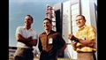 Die Crew von Apollo 8 (Lovell, Anders und Borman %2d v.l.n.r.) beim Roll%2dout (im Hintergrund wird die Saturn%2dV%2dRakete aus dem Vehicle Assembly Building gerollt). Bild: NASA (68%2dHC%2d609)
