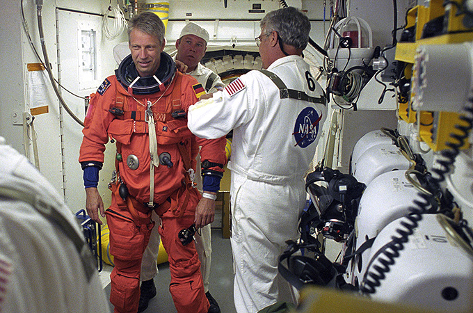 Der deutsche ESA-Astronaut Thomas Reiter direkt vor dem Start. An der Spitze der Raumfähre wird er von Technikern für das Einsteigen bereit gemacht. Von diesem Raum ganz oben am Startturm geht es direkt in die Luke des Shuttles. Dann schwenkt der Turm zur Seite und die Shuttle-Crew wartet auf das Ende des Countdowns. 
Bild: NASA