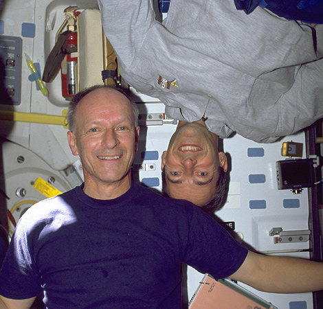 In Schwerelosigkeit gibt es kein „Oben“ und „Unten“. Jeder dieser beiden Astronauten – Claude Nicollier aus der Schweiz (im blauen Hemd) und Jean-Francois Clervoy aus Frankreich – kann von sich selbst sagen, dass er „richtig” herum und der andere auf dem Kopf steht. 
Bild: NASA, ESA