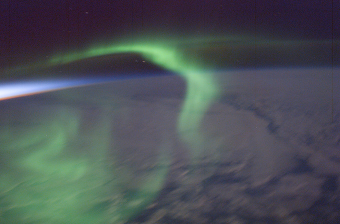 Blick aus der ISS auf die Erde – hier mit Polarlichtern. Sie entstehen, wenn geladene Teilchen von der Sonne auf die Atmosphäre treffen. 
Bild: NASA