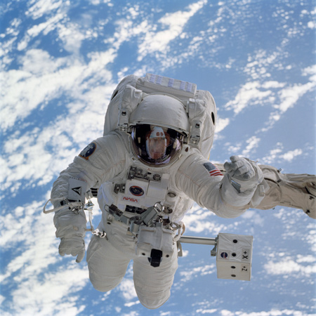 Der Amerikaner Michael L. Gernhardt: Mit seinen Füßen ist er an einem Roboter-Arm befestigt. 
Bild: NASA