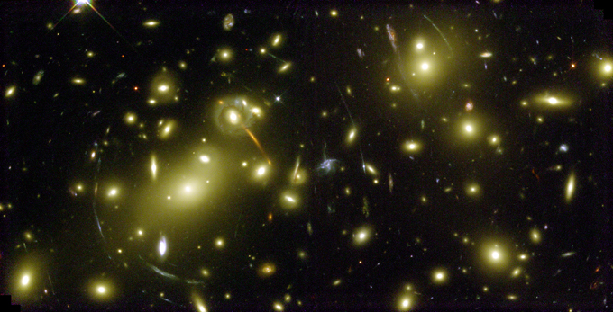 Hier sehen wir das kurvenförmig verzerrte Licht weit entfernter Galaxien. Es wird auf dem Weg zu uns durch näher gelegene Sternenhaufen abgelenkt. Dieser sogenannte Gravitationslinsen-Effekt zeigt also die Krümmung des Raumes durch große Massekonzentrationen. Bild: NASA, ESA, Hubble 