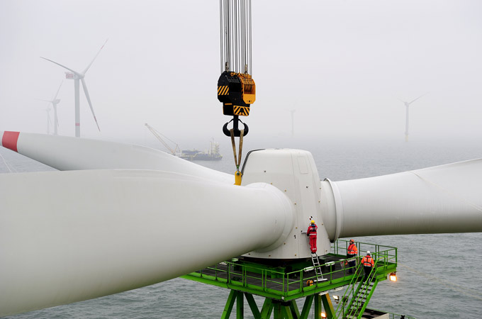 Hier montieren die Spezialisten ein Windrad in der Nordsee. Die Aufnahme macht die riesigen Ausmaße der Windräder deutlich. 
Bild: Areva (J. Oelker)